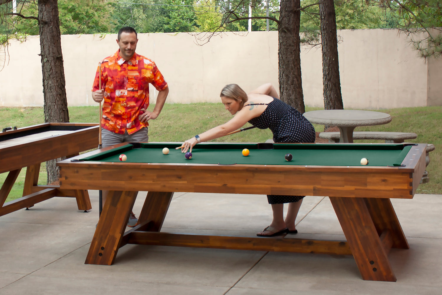 Legacy Billiards 7 Ft Barren Outdoor Pool Table in Natural Acacia Finish with People Playing Pool Outside