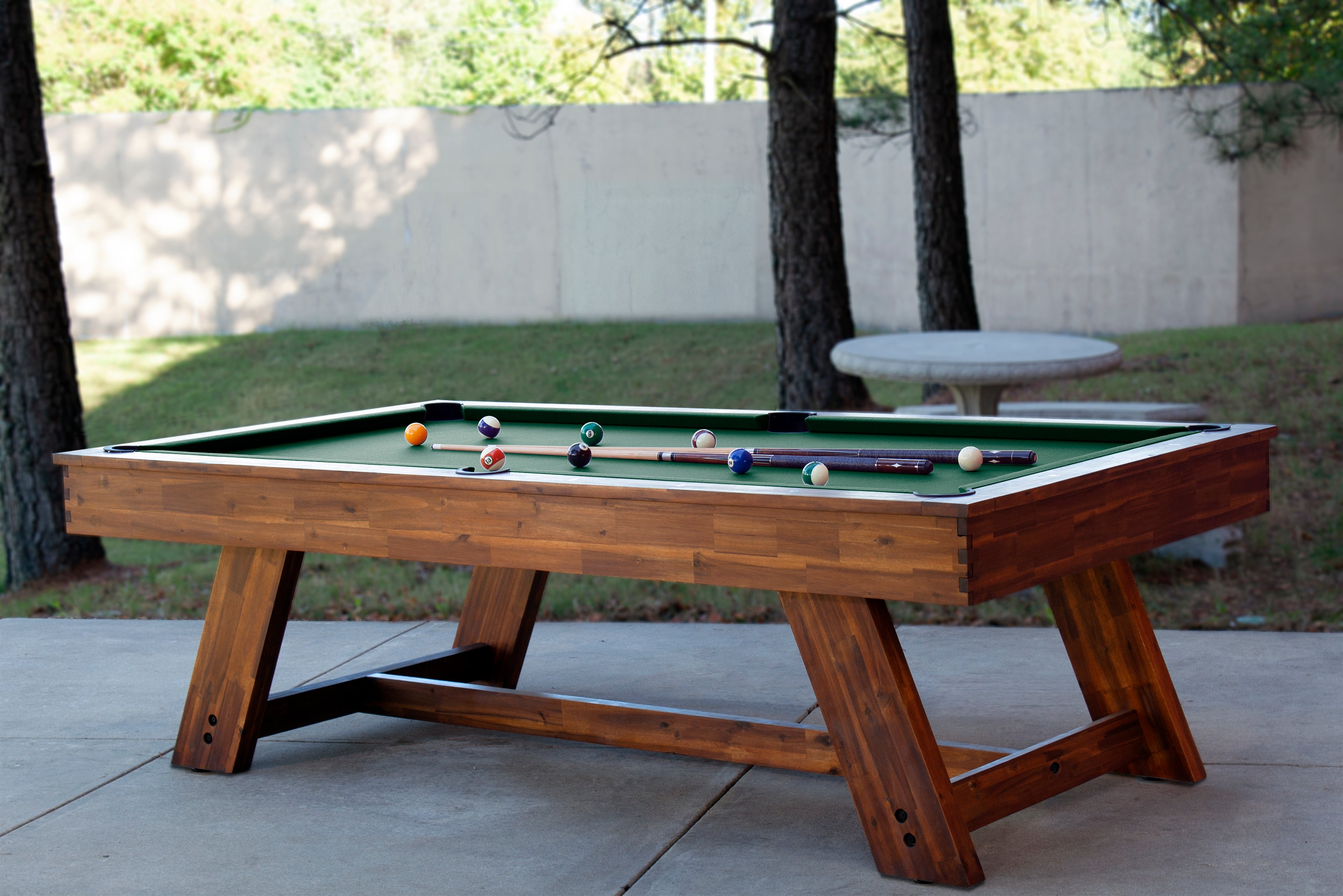 Legacy Billiards 7 Ft Barren Outdoor Pool Table in Natural Acacia Finish Outdoor Setting with Pool Balls and Cues on the Table